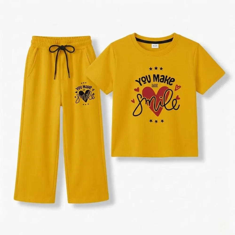 Yellow casual outfit for kids, consisting of a t-shirt and sweatpants, with a heart design and the phrase 'You make me smile'.