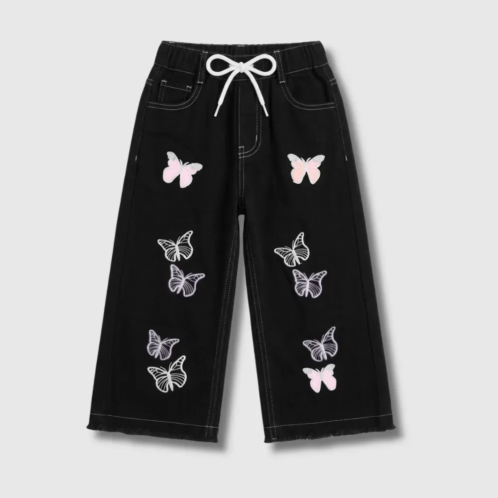 Black jeans with white and pink butterfly embroidery and a white drawstring.