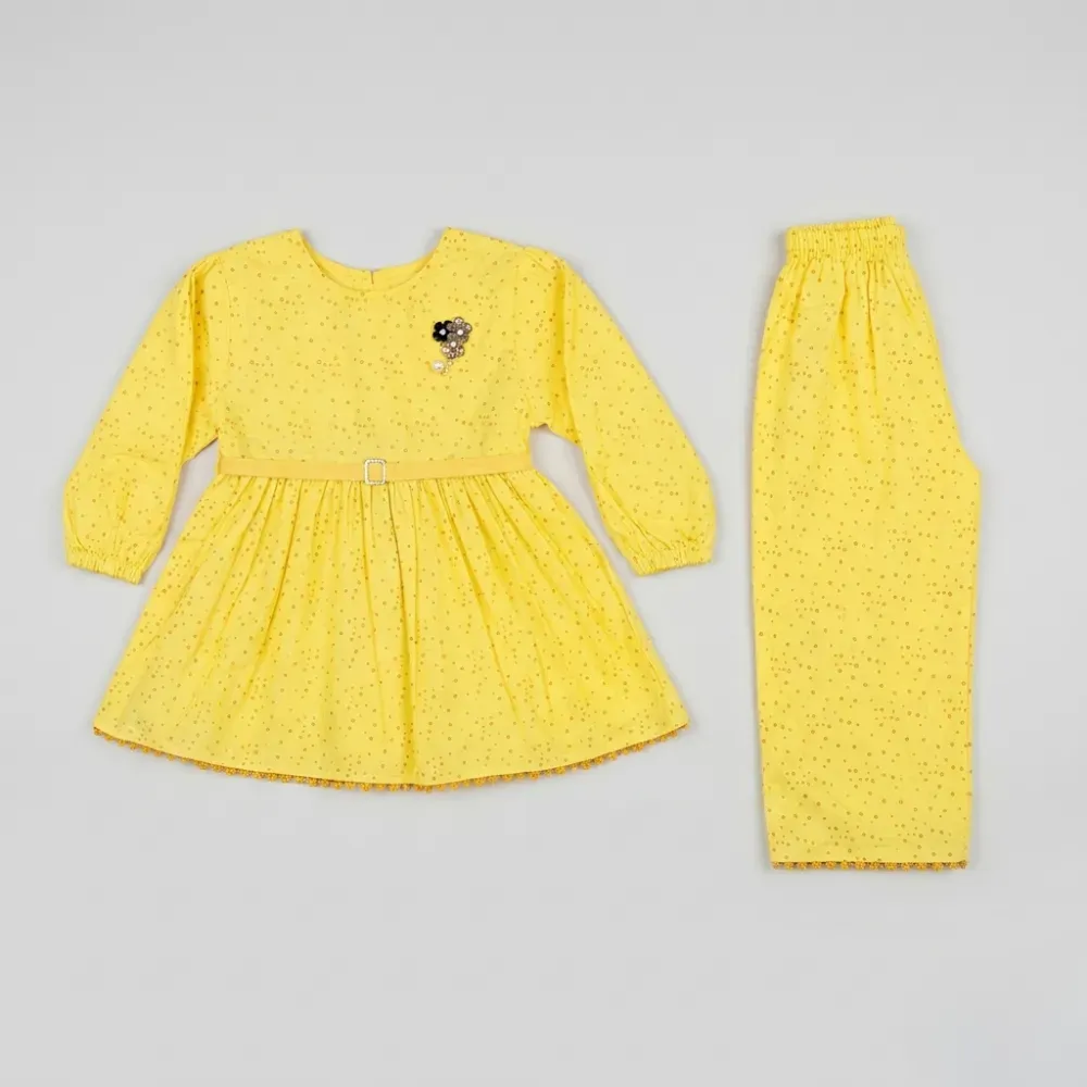 Yellow two-piece outfit for girls, featuring a peplum top with floral embroidery and matching pants, both with small golden polka dots on a lightweight material.