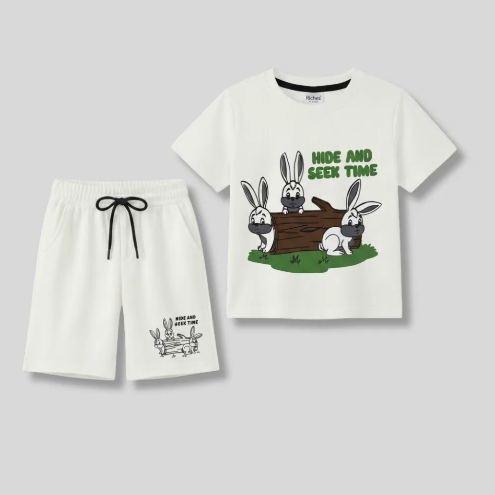 White kids outfit with cartoon rabbits and green text on the tshirt, black drawstring on the shorts.