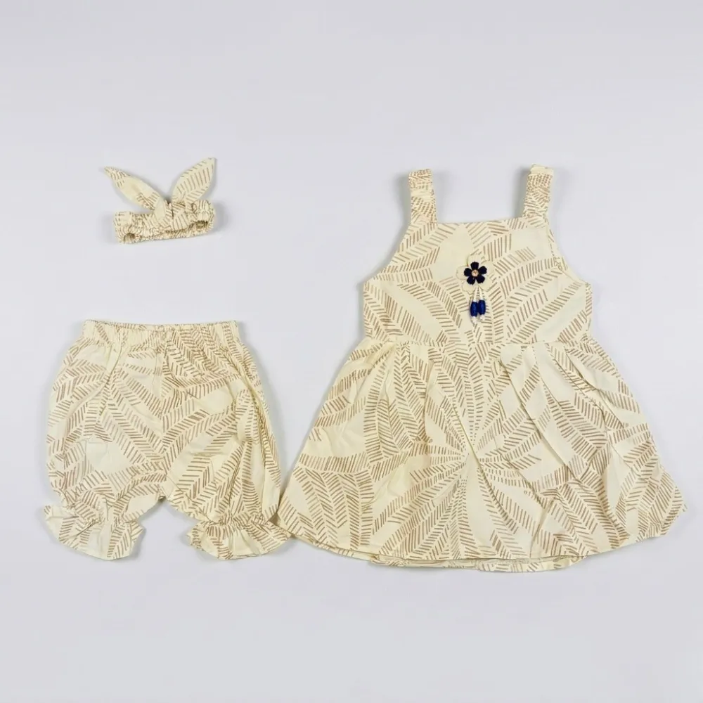 cream-colored toddler outfit with leaf pattern, blue flower embellishment, and matching headband